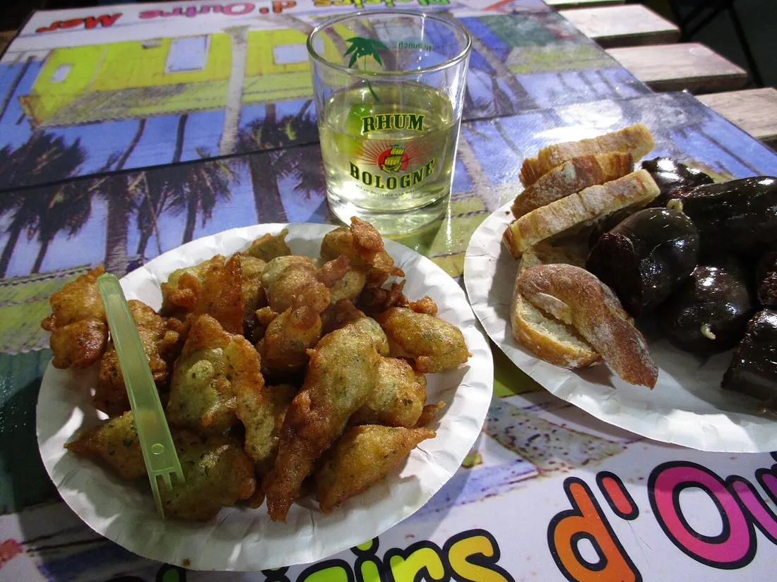 Apéritif antillais : accras de morue, boudin créole, pain et verre de rhum sur une table
