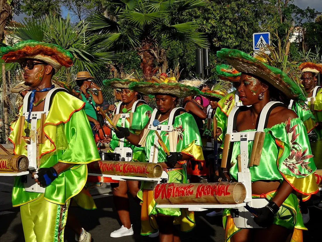 Groupe costumé en habits verts et jaunes défilant en musique dans les rues de Fort-de-France lors d'un festival en Martinique