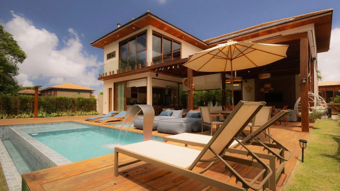 Villa tropicale de location avec piscine privee, terrasse en bois et transats, illustrant un bien Airbnb a fort potentiel locatif en Guadeloupe