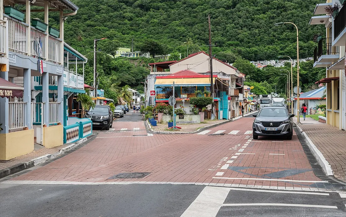 Centre-bourg de Deshaies en Guadeloupe avec ses maisons créoles colorées, commerces et rue pavée au pied des collines verdoyantes
