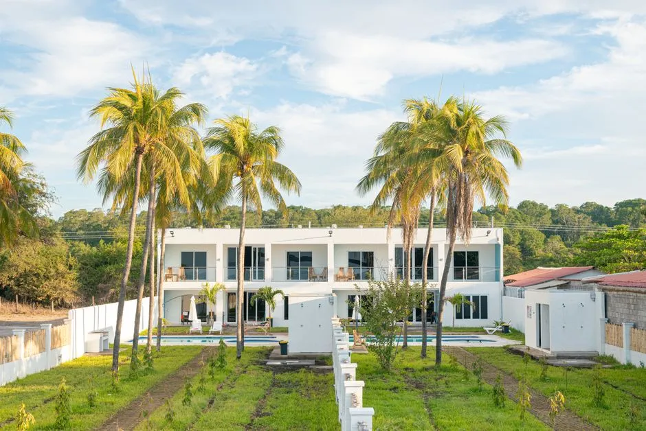 Villa de location meublée à deux niveaux avec piscine, transats et cocotiers, illustrant un hébergement de tourisme susceptible d'obtenir un classement en étoiles