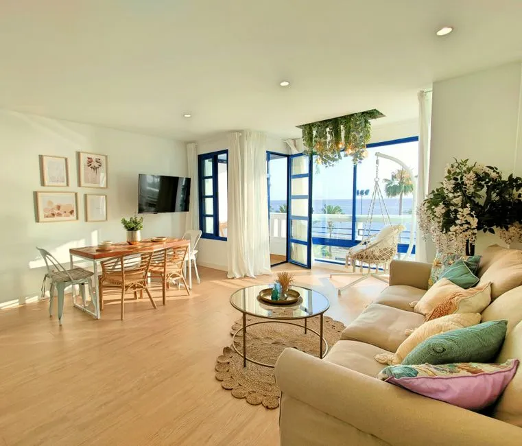Salon lumineux d'une location de vacances tropicale avec vue mer, prêt à être confié à une conciergerie