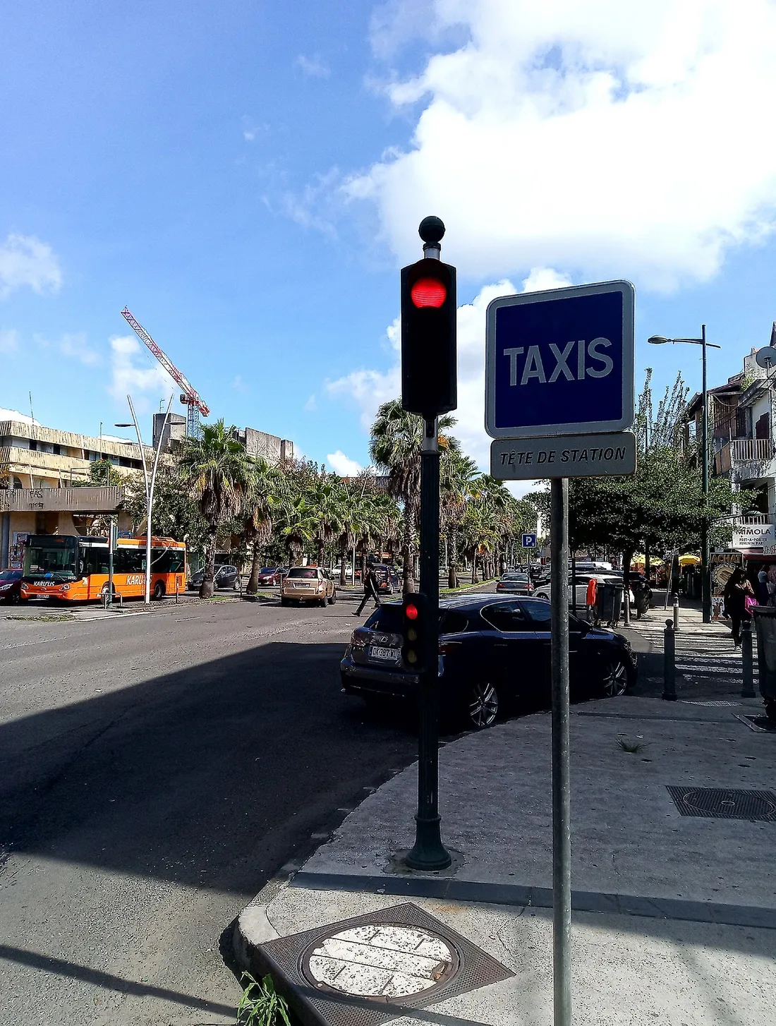 Avenue urbaine de Pointe-à-Pitre avec une station de taxis, un bus de ville et la circulation au cœur de l'agglomération guadeloupéenne