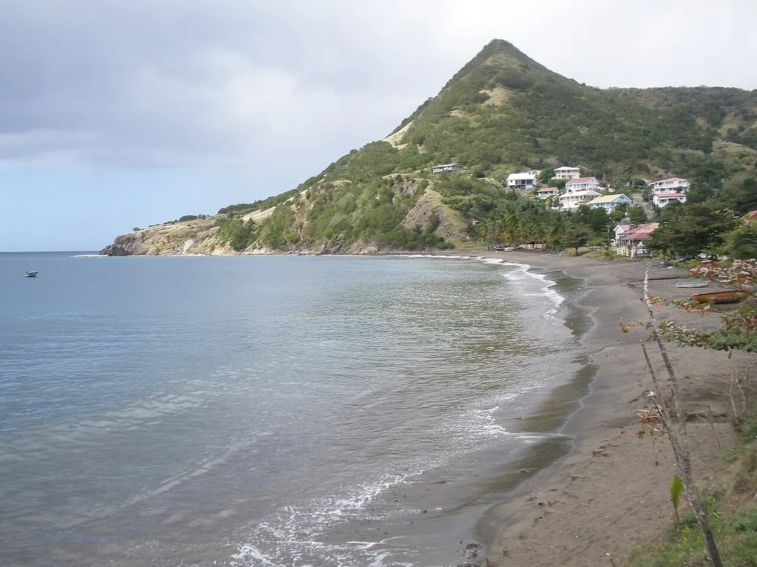 Plage de Petite Anse aux Anses-d'Arlet en Martinique, mer calme des Caraibes et village au pied du morne