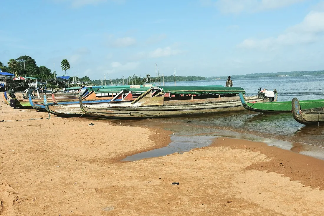 Pirogues traditionnelles en bois echouees sur la rive sablonneuse du fleuve Maroni en Guyane