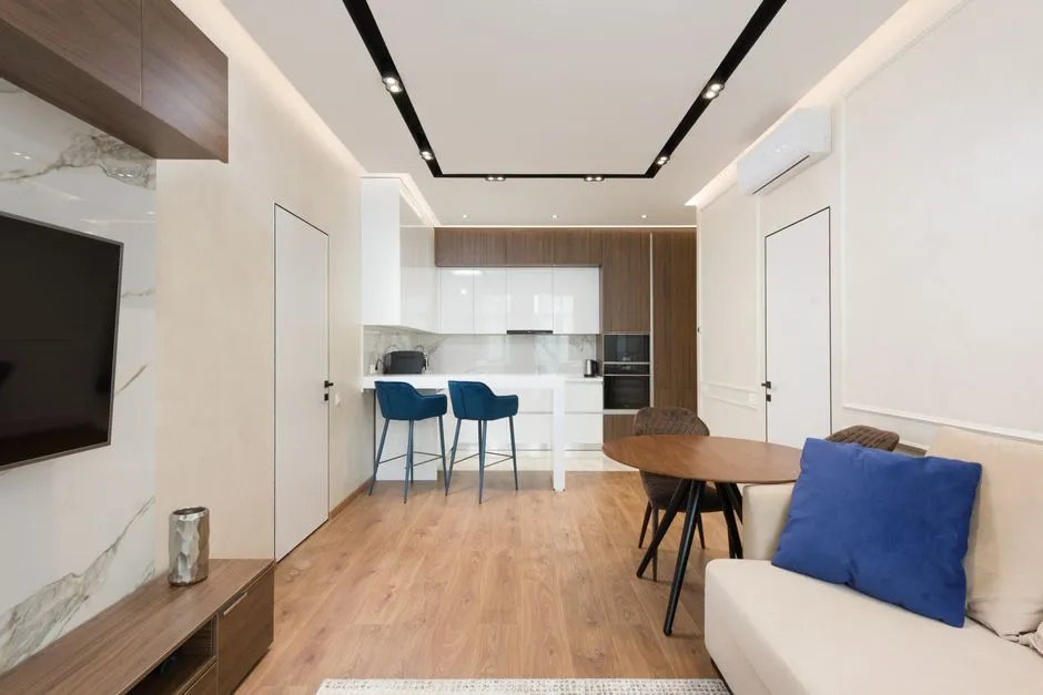 Intérieur d'un appartement meublé moderne avec salon, cuisine ouverte et climatisation, type de bien éligible au statut LMNP
