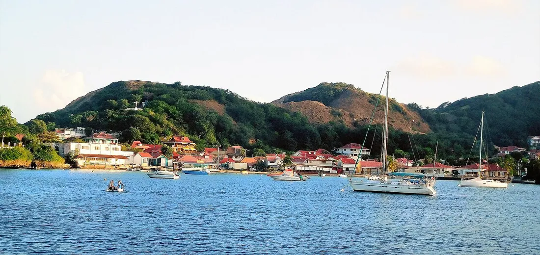 Le bourg de Terre-de-Haut aux Saintes, ses maisons aux toits rouges au bord de la baie avec voiliers au mouillage