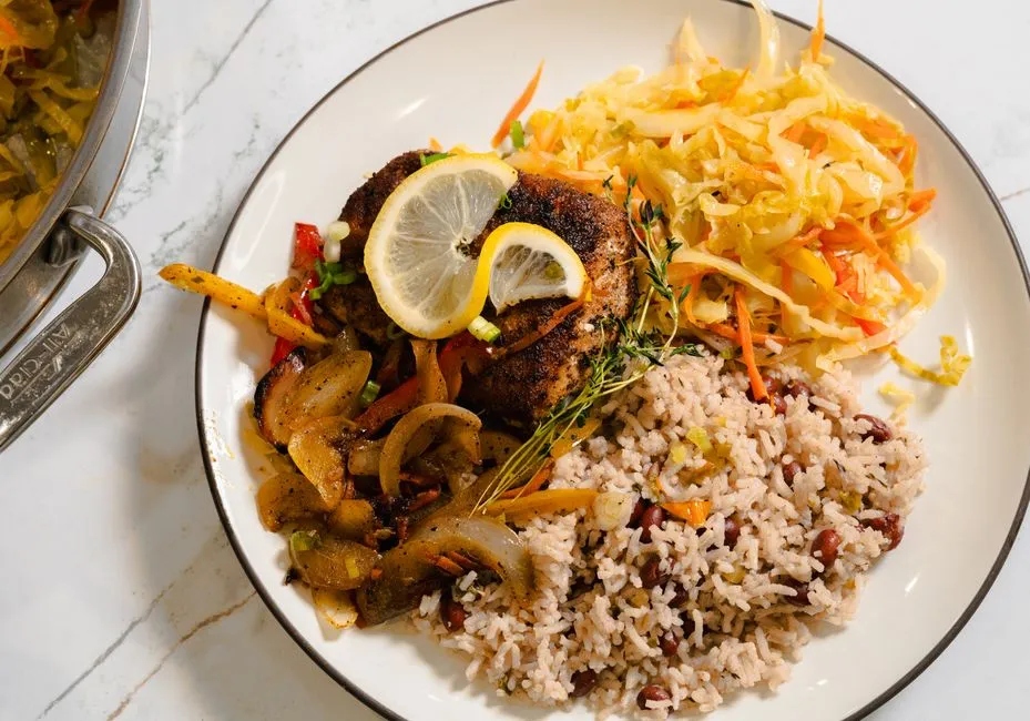 Assiette de cuisine créole caribéenne avec riz aux haricots rouges, poisson épicé, légumes sautés et chou râpé, un repas local complet et abordable