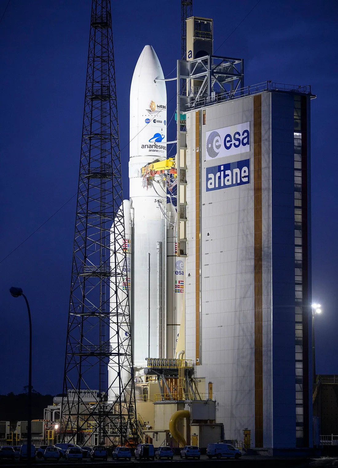 Lanceur Ariane dressé sur son pas de tir au Centre Spatial Guyanais de Kourou, au crépuscule, avant un lancement