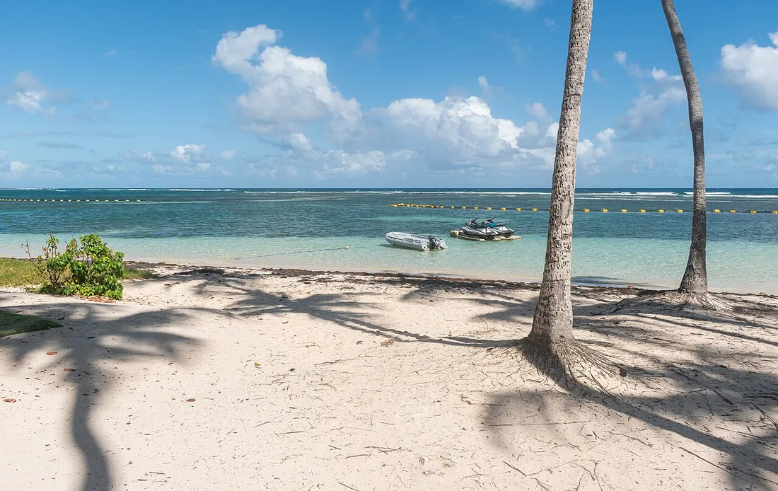 Lagon peu profond et translucide de la plage de la Caravelle a Sainte-Anne, protege par la barriere de corail en arriere-plan