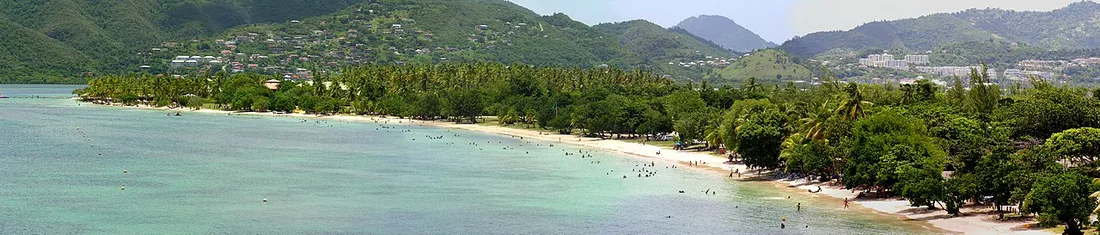 Vue panoramique de la plage de la Pointe Marin et du bourg de Sainte-Anne en Martinique, avec eaux turquoise et collines verdoyantes