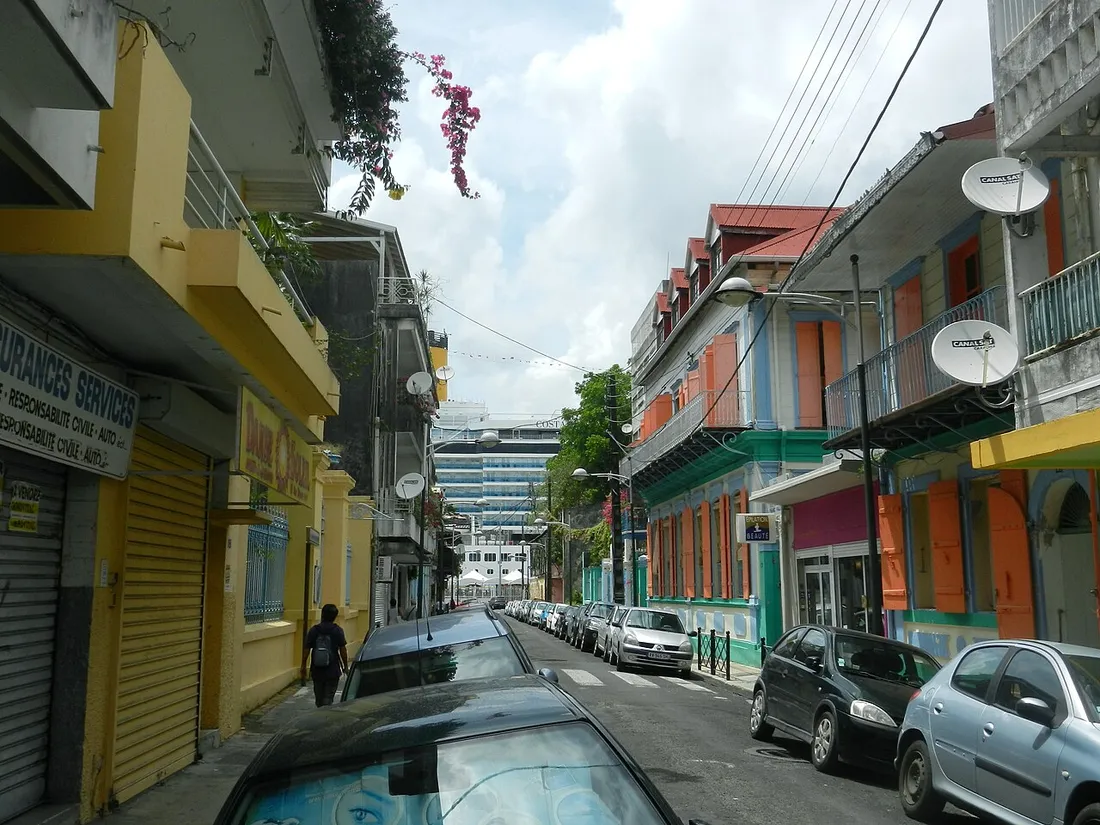 Rue commerçante colorée de Pointe-à-Pitre en Guadeloupe, bordée de boutiques et de commerces où s'appliquent la TVA et l'octroi de mer